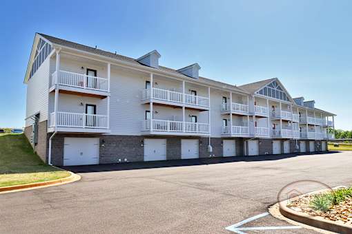 The rear of a one bedroom stacked apartment home with balconies and patios.