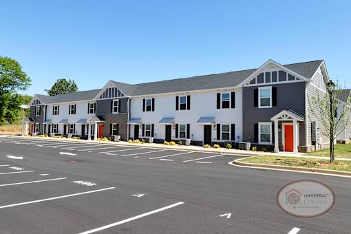 A row of two and three bedroom apartments with orange accent doors.