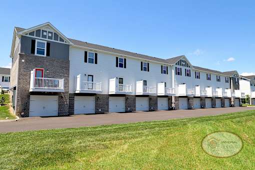 The rear of a two and three bedroom apartment home with balconies and drive under garages.