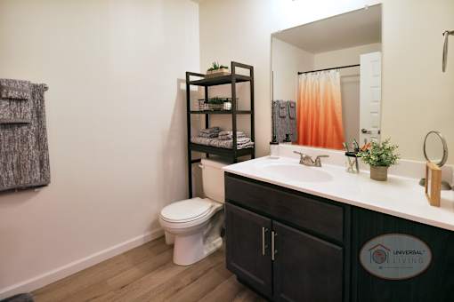 A bathroom with a toilet, sink, and a mirror.