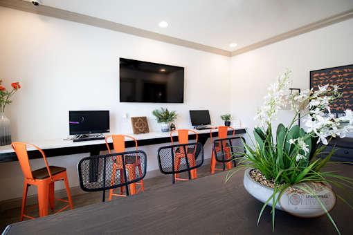 The clubhouse business center with barstool seating, computers, flat screen TV, and free Wi-Fi.