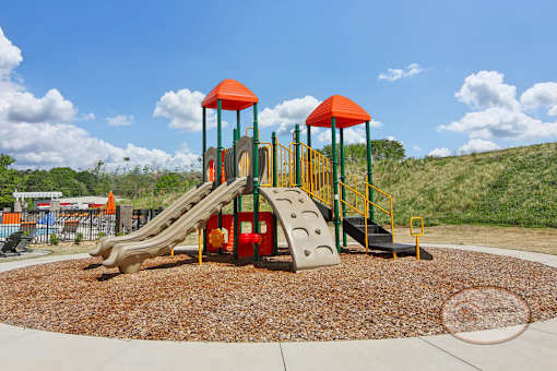 A soft topped playground with slide and jungle gym.