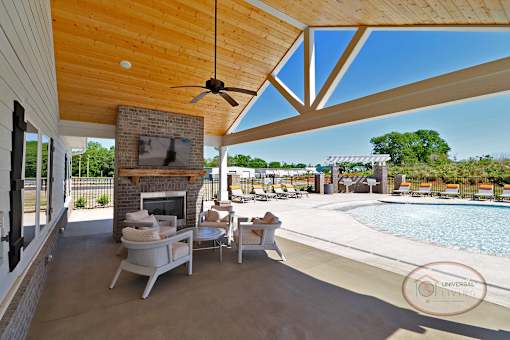 The poolside lounge with flat screen TV, lounge seating, and a table with chairs.