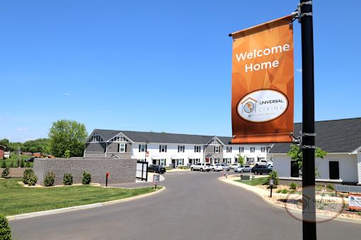 An orange banner reading "Welcome Home" in front of a row of apartments.