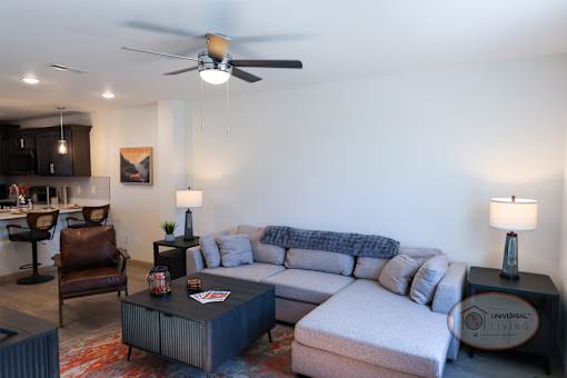 A living room with a white couch and a brown leather chair.