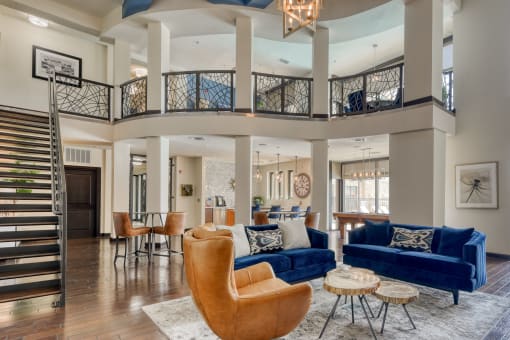 a living room with couches and chairs and a spiral staircase