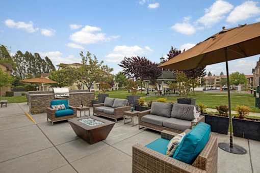 A patio with furniture and a large umbrella.