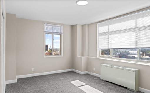Empty bedroom with city views and carpet flooring at Dominion Towers Apartments, Arlington, 22204
