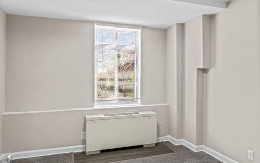 Bright bedroom with radiator and window blinds at Dominion Towers Apartments, Arlington, Virginia