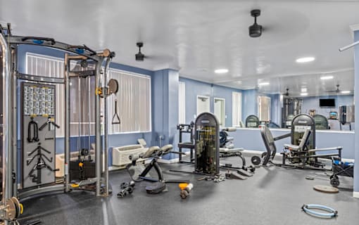 Fitness center with workout equipment and blue walls at Dominion Towers Apartments, Arlington, 22204