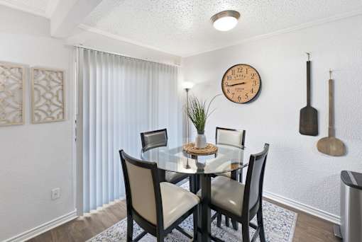 A dining room with a table set for four.