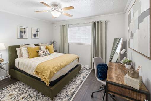 A bedroom with a bed, desk, and chair.