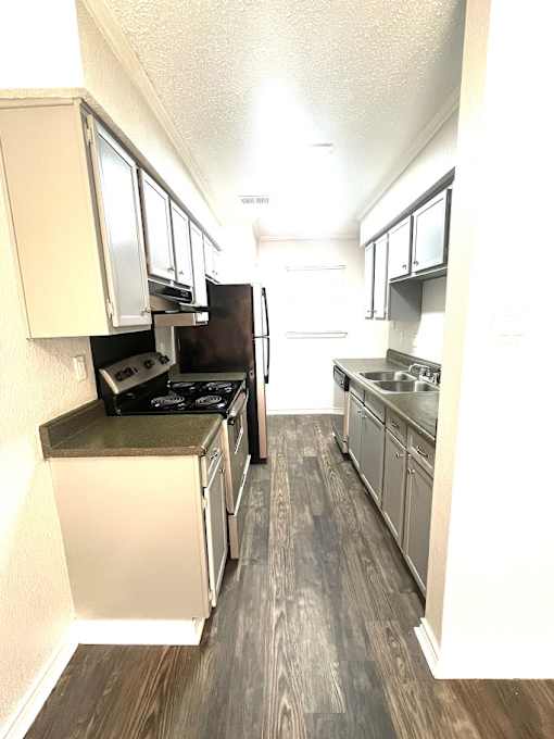 A kitchen with a black stove top oven and a black refrigerator.