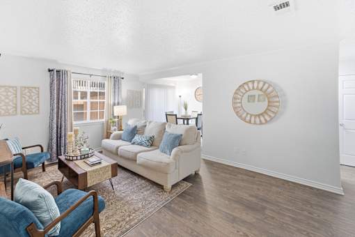 A living room with a white couch and a wooden coffee table.
