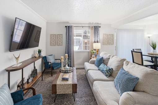 A living room with a large couch, a coffee table, and a television.