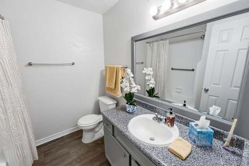 A bathroom with a toilet, sink, and shower.