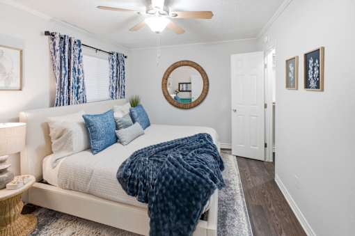 A bedroom with a white bed and blue pillows.