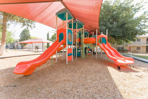 Playground with shade covering and colorful equipment at Cantera Apartments, El Paso, 79935