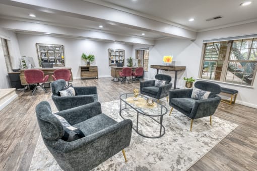 Clubhouse seating area with gray armchairs and coffee table at Le Montreaux Apartments, Texas, 78759