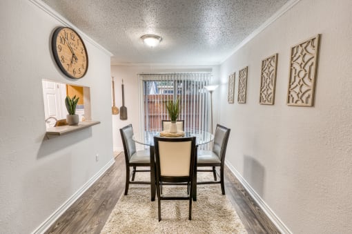 Modern dining room with round table and wall art at Le Montreaux Apartments, Texas