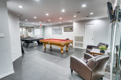 Recreation room with pool table and leather chairs at Le Montreaux Apartments, Austin, TX