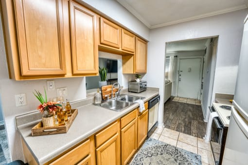 Updated kitchen with wooden cabinets and tile flooring at Le Montreaux Apartments, Austin, Texas