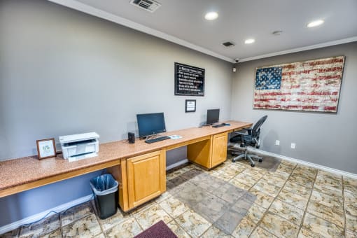 Business center with computer workstations and american flag at Le Montreaux Apartments, Austin, TX