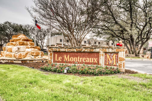 Property entrance sign with stone landscaping at Le Montreaux Apartments, Austin, Texas