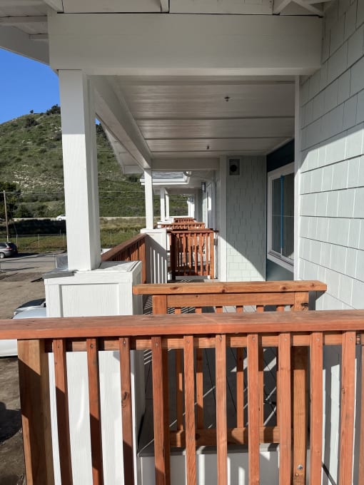 a view of a porch with a wooden railing
