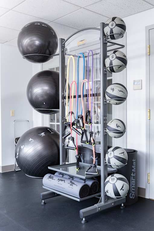 A gym with a SmartMax weight rack and a black exercise ball.