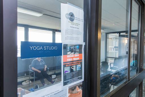 A yoga studio is advertised on a poster in a window.