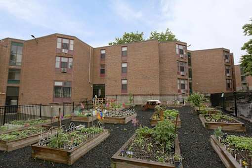 A garden in front of a brick apartment building.