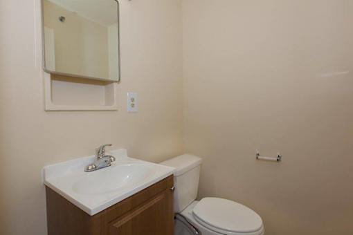 A white toilet sits next to a sink in a bathroom.