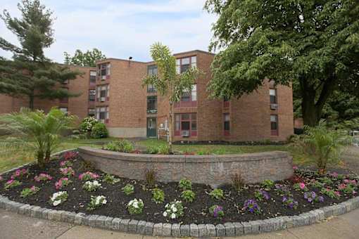 A brick building with a flower bed in front.