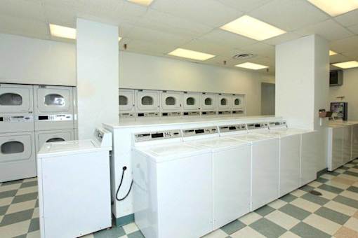 A laundromat with a row of washers and dryers.