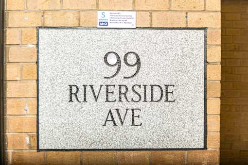 A sign on a wall that says 99 Riverside Ave.