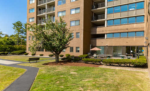 A large apartment building with a tree in front of it.