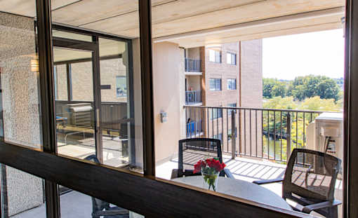 Common area balcony with a table and chairs overlooking a courtyard.