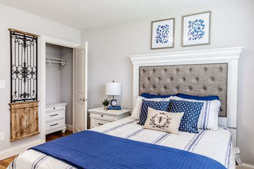 A bedroom with a bed, nightstand, and a wooden cabinet.