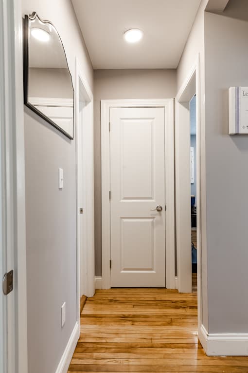 A white door is in the middle of a hallway.