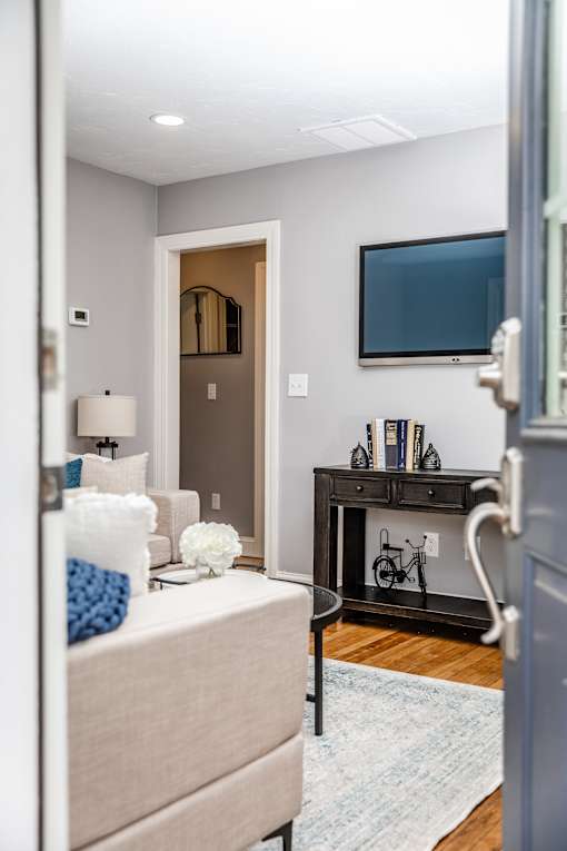 A bedroom with a bed, a dresser, a TV, and a bicycle on the wall.