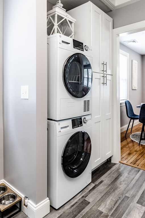 A white washer and dryer stacked on top of each other in a laundry room.