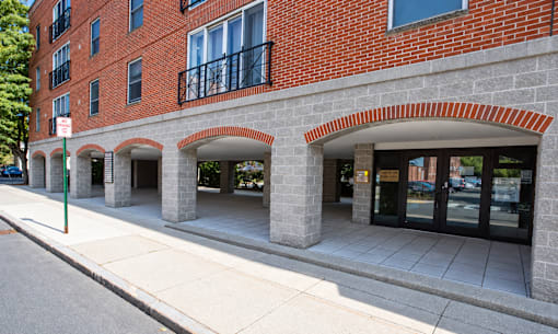 A red brick building with arches and a black metal railing.