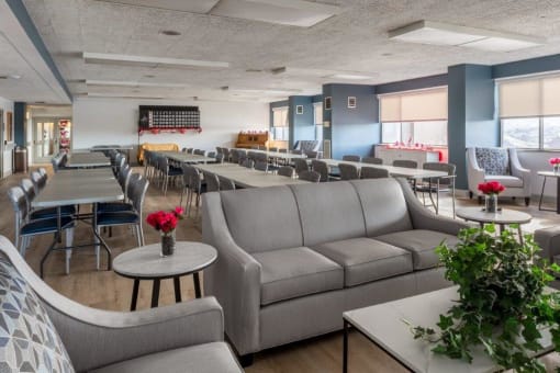 a common room with couches tables and chairs and tables