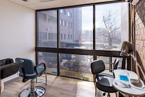 a room with a large window and tables and chairs