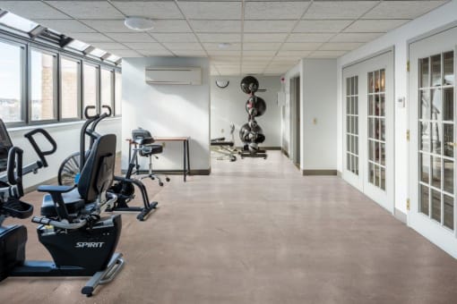 a workout room with exercise equipment and windows in a building