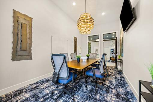 Conference room with wood table and mesh chairs at Ardmore at Prosperity Apartments, Tennessee