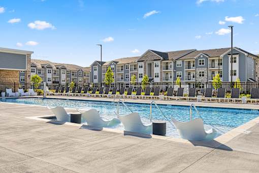 Resort style pool with lounge chairs and apartment buildings at Ardmore at Prosperity Apartments, Tennessee