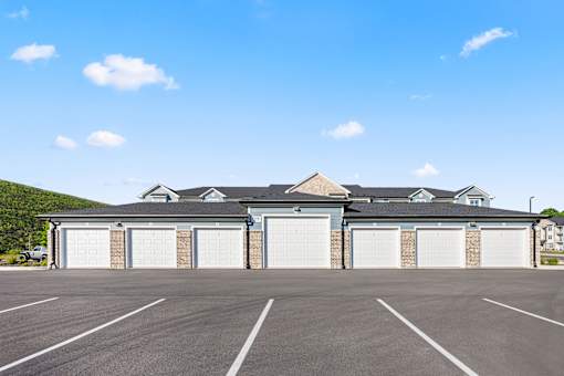 Private garages with white doors and brick accents at Ardmore at Prosperity Apartments, Tennessee, 37932