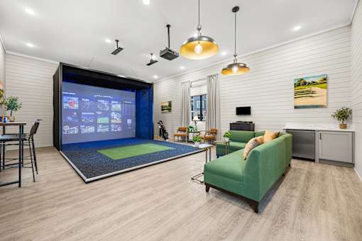 Indoor golf simulator lounge with seating area at Ardmore at Prosperity Apartments, Knoxville, TN 37932